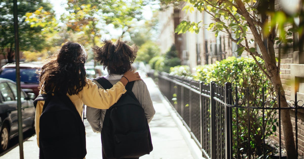 How to move children in a Las Vegas casino? - Back view of unrecognizable girls walking together along street while returning home from school