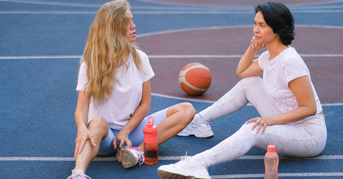 How to "speak" Russian, if you don't speak Russian? - Full length of confident young ladies in sportswear speaking while having break on court after exercising with water bottles near basketball in daylight