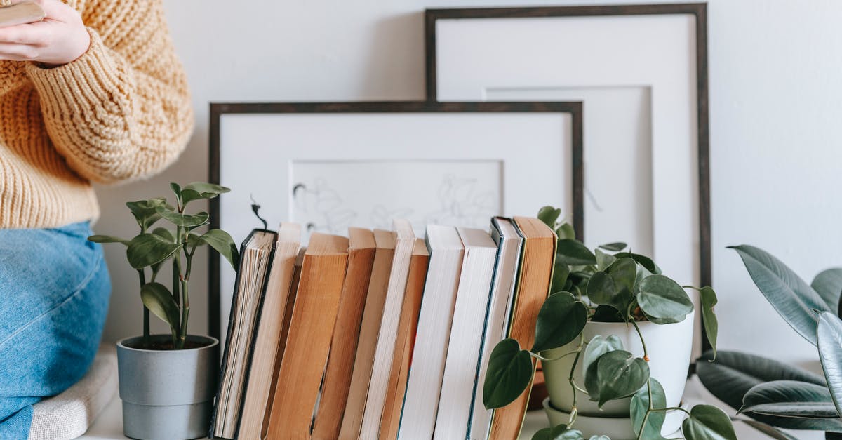 how to read the weather in this picture [closed] - Crop female in casual clothes holding opened book and sitting on shelf with collection of books and plants and photo frames on white wall in light room