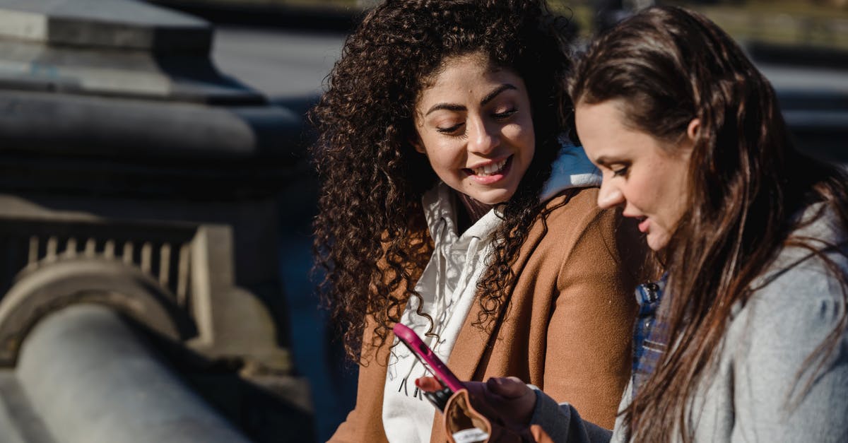 How to register with the ALDI talk mobile app? - Happy women using smartphone on city street on spring