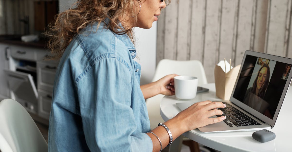 How to stay connected with friends, family while abroad? - Woman in Blue Denim Jacket Using Macbook Pro