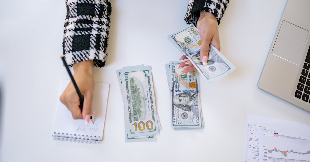 How to take money to Iran? - A Person Taking Notes while Counting Money