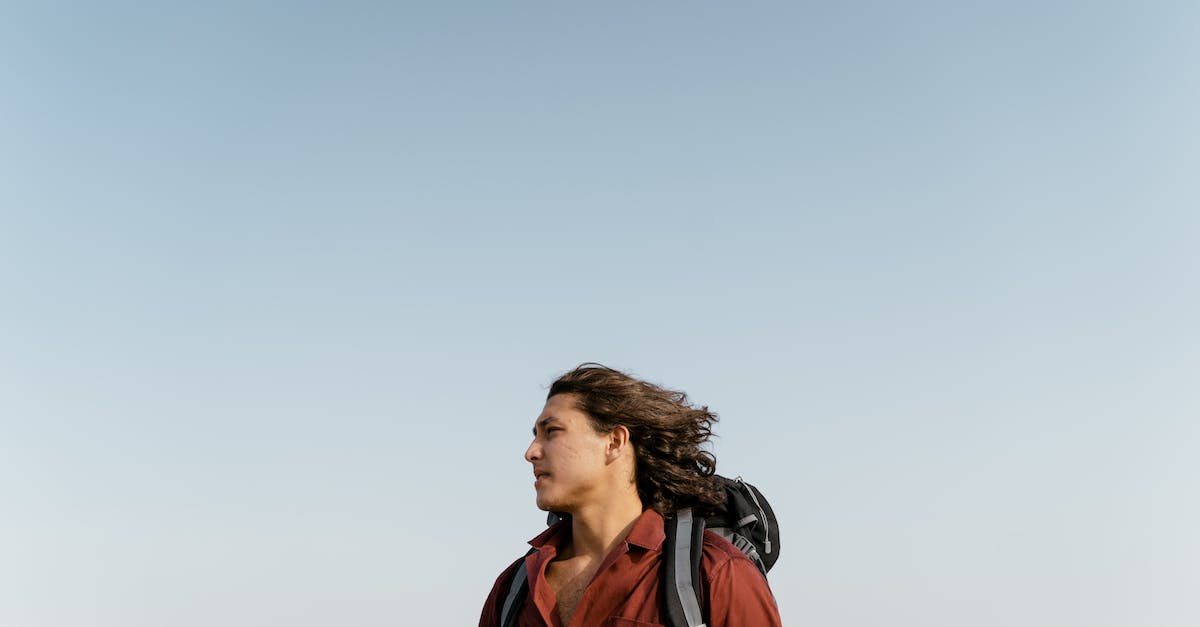 How to travel if you are stateless? - Man in Red Jacket Standing Under White Sky