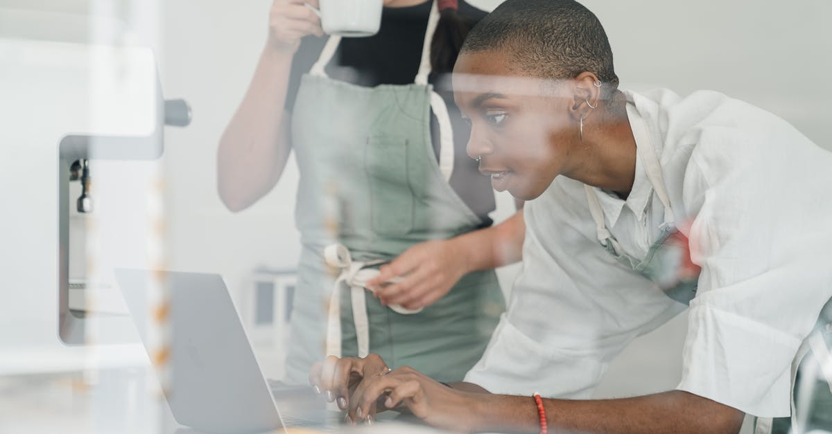 How to understand the registration rules in Serbia? - Black female barista together with colleague using laptop at work