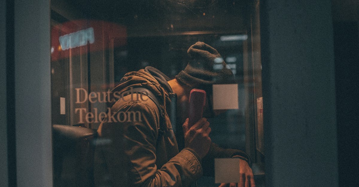 How to use payphone for calls within Cuba? - Young man talking on telephone in public call box