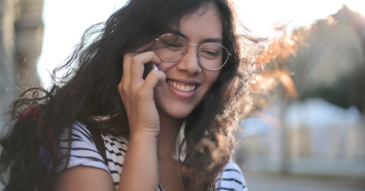 How to use payphone for calls within Cuba? - Cheerful young woman making phone call on street