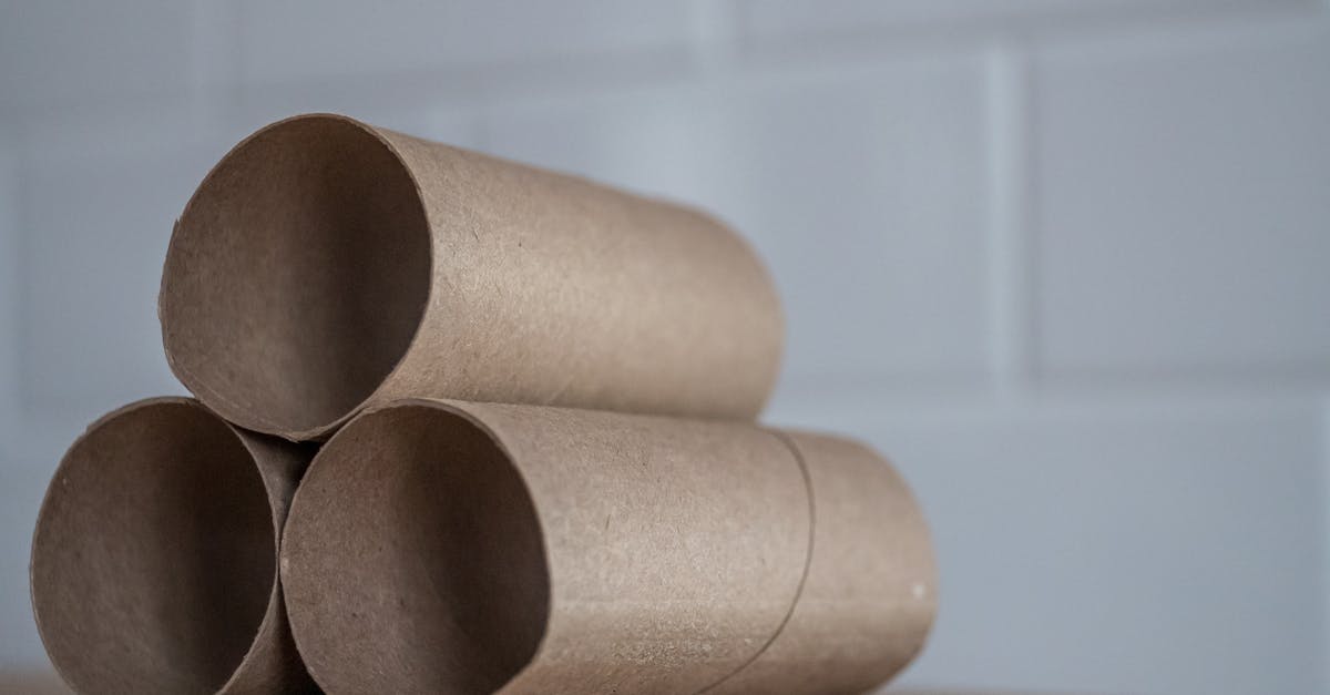 How to use toilet paper - Closeup of stacked brown cardboard tubes of finished toilet paper placed on wooden table