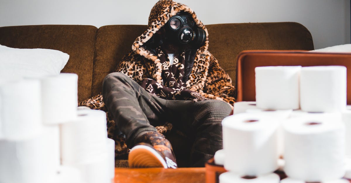 How to use toilet paper - Unrecognizable trendy man in respirator near pile of toilet paper