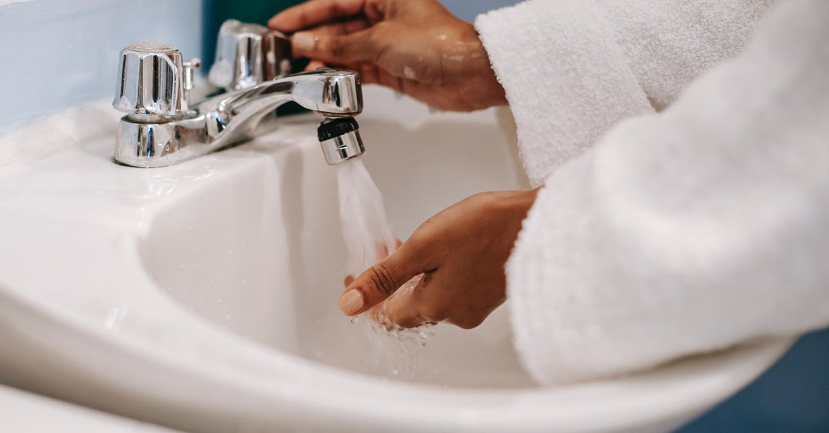 How to wash hands if tap water is too hot? - Crop ethnic woman in robe washing hands in bathroom