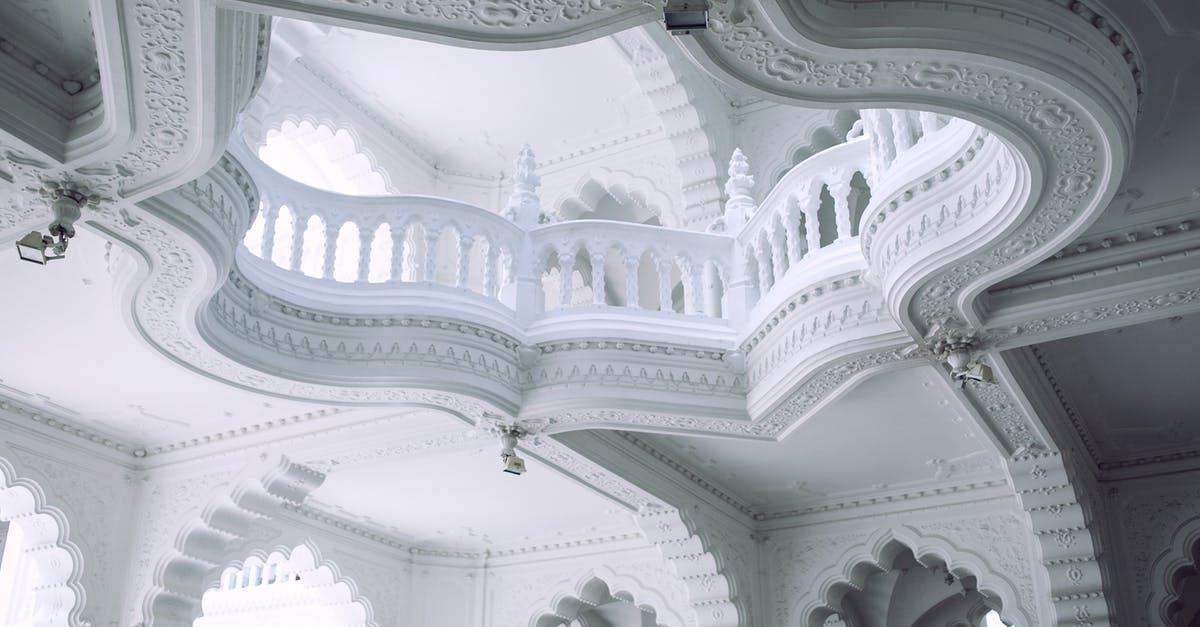 Hungary - Schengen Visa processing time from India - From below of old stone building interior with decorative white walls and fenced balcony in sunlight