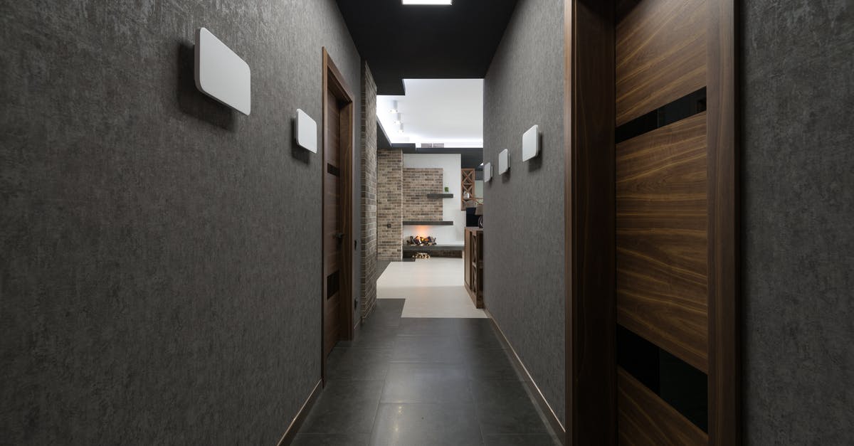 Hypothetically, how long would it take to circumnavigate New Zealand by foot? - Long corridor with gray walls and wooden doors leading to light living room with decorations at home with stylish design