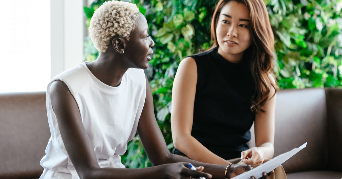 I-539 Visa Extension Question - Diverse women talking about job while discussing contract and looking at each other in conference hall