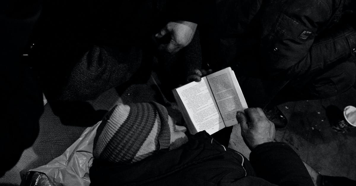 I need help with the documents that i should provide? - Black and white of homeless man lying on floor and reading book in night shelter for homeless