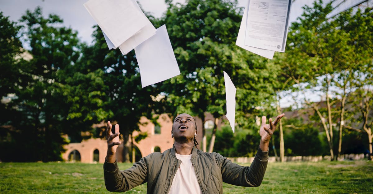 I need to get a 3 month extension on my ESTA visa - Overjoyed African American graduate tossing copies of resumes in air after learning news about successfully getting job while sitting in green park with laptop