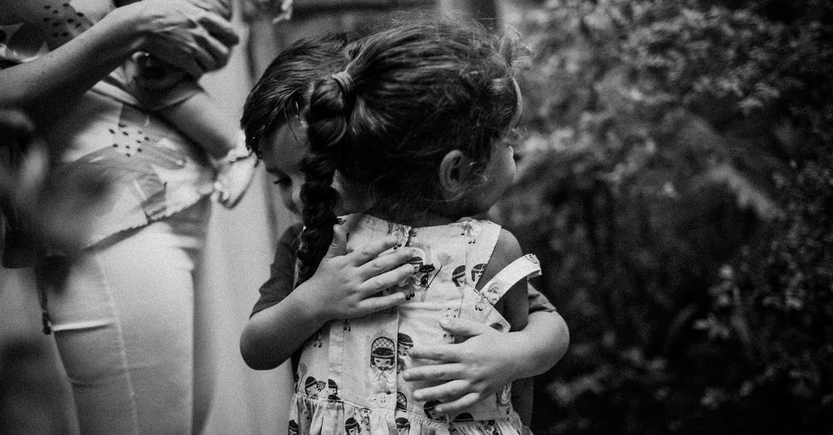 I want my brother and mother to move to Australia [closed] - Black and white of anonymous adorable little girl and boy hugging each other while standing on street with mother