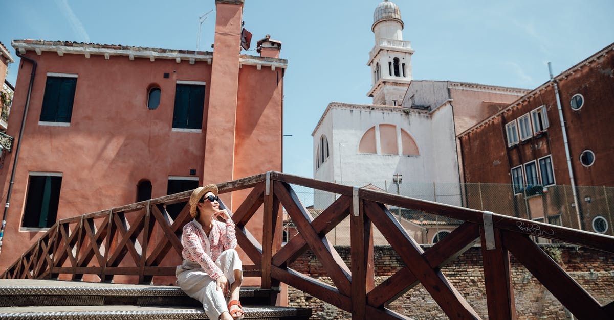 I want to travel by rail in Europe by Eurail - Woman sitting on steps near old building