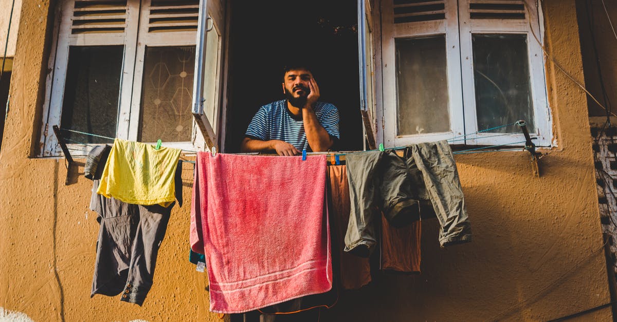 Ideas for versatile clothes in northern India - Man By An Open Window With Assorted Clothing Hanging On Clotheslines