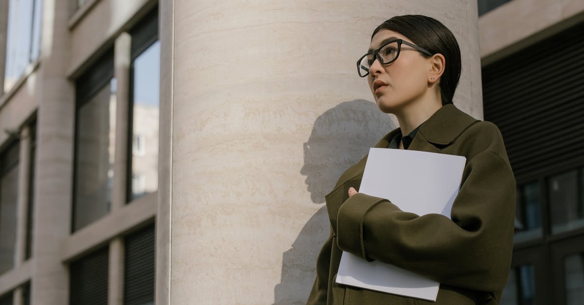 Identifing building in Lancaster - Woman in Black Framed Eyeglasses and Black Coat Holding White Printer Paper