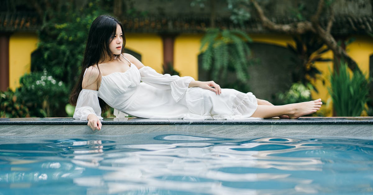 Identify the building depicted in this charm - Attractive Asian woman lying on edge of pool