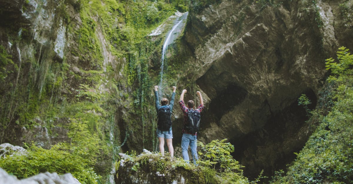 Identify this waterfall in Myanmar - Group of People Standing on Rocky Mountain