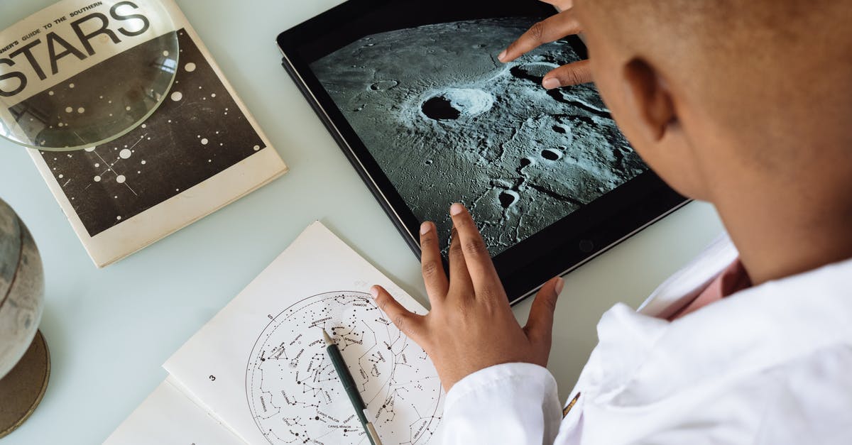 Ijen crater and batu secret zoo from Surabaya - Crop African American student studying craters of moon on tablet at observatory