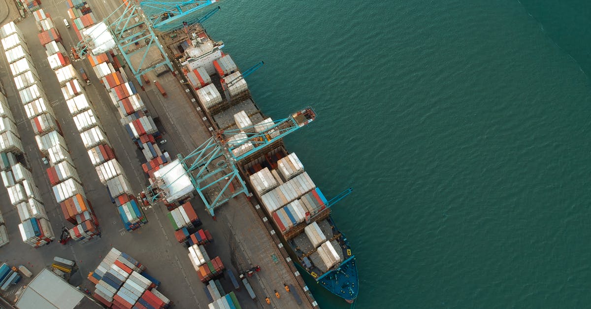 Import goods from America to Germany - Top view of harbor with containers and cargo ships located near calm rippling sea water