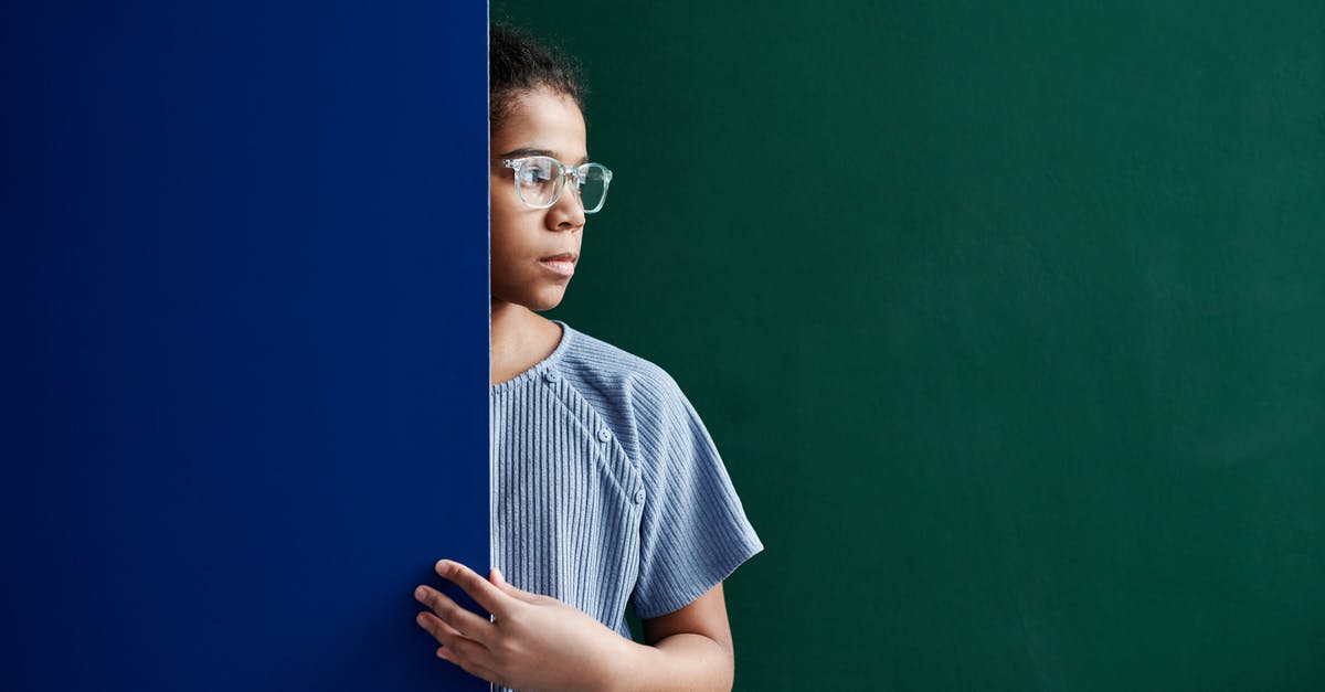 In practice, what is the distinction between ESTA and visas? - A Woman in Blue Shirt Standing Between Green and Blue Wall