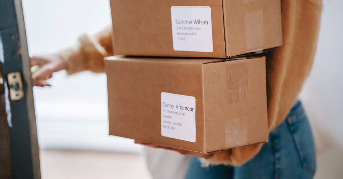 In what language should I address foreign customs and immigration? - Crop unrecognizable woman carrying boxes and entering post office