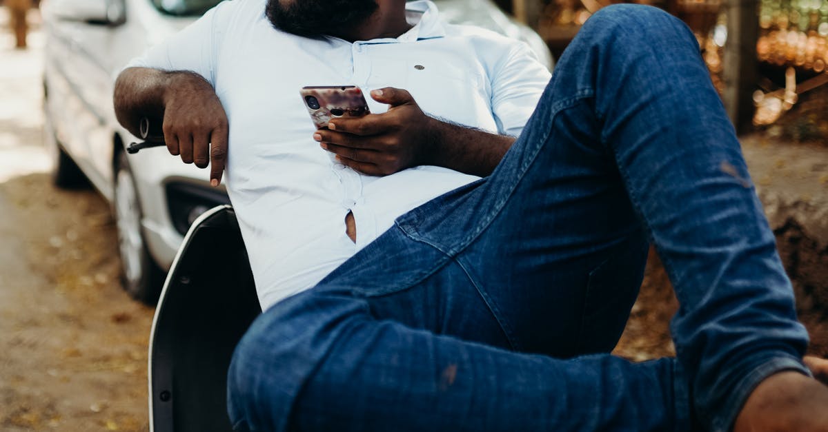 Indian customs rules on bringing packed iPhone [duplicate] - Man in White Dress Shirt and Blue Denim Jeans Sitting on Chair