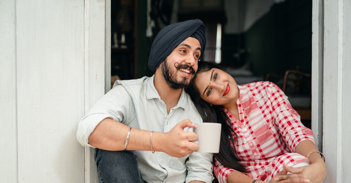 Indian passport threading coming off - Positive married couple relaxing on threshold of house