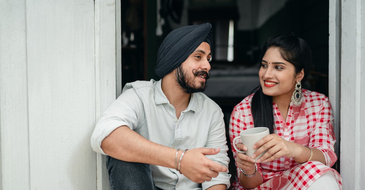 Indian passport threading coming off - Positive Indian spouses in casual outfits sharing interesting stories while drinking morning coffee on doorstep of house