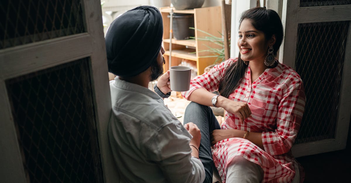 Indian passport threading coming off - Young Indian spouses having pleasant conversation and drinking coffee while sitting on floor at home on day off