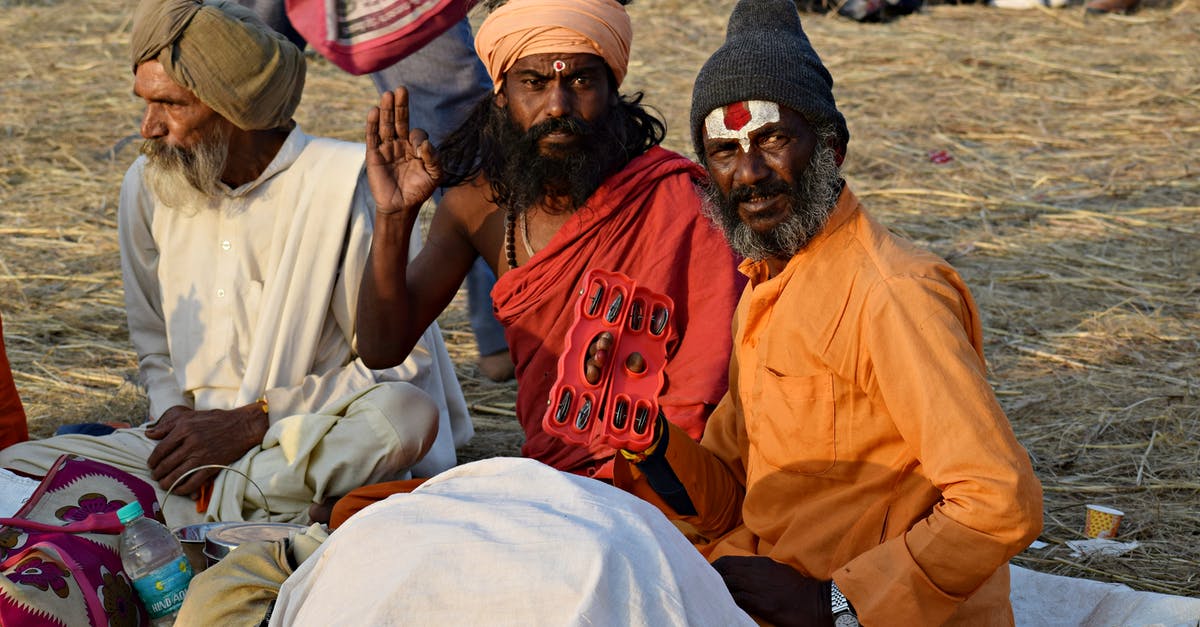 Indian visa re-entry and cancellation - Man in Orange Crew Neck T-shirt Sitting Beside Woman in White Dress