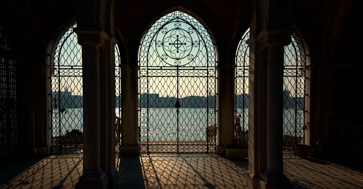 Inle lake entrance fee - Hall of ancient stone building with big arches with metal ornaments leading to waterfront on sunny day