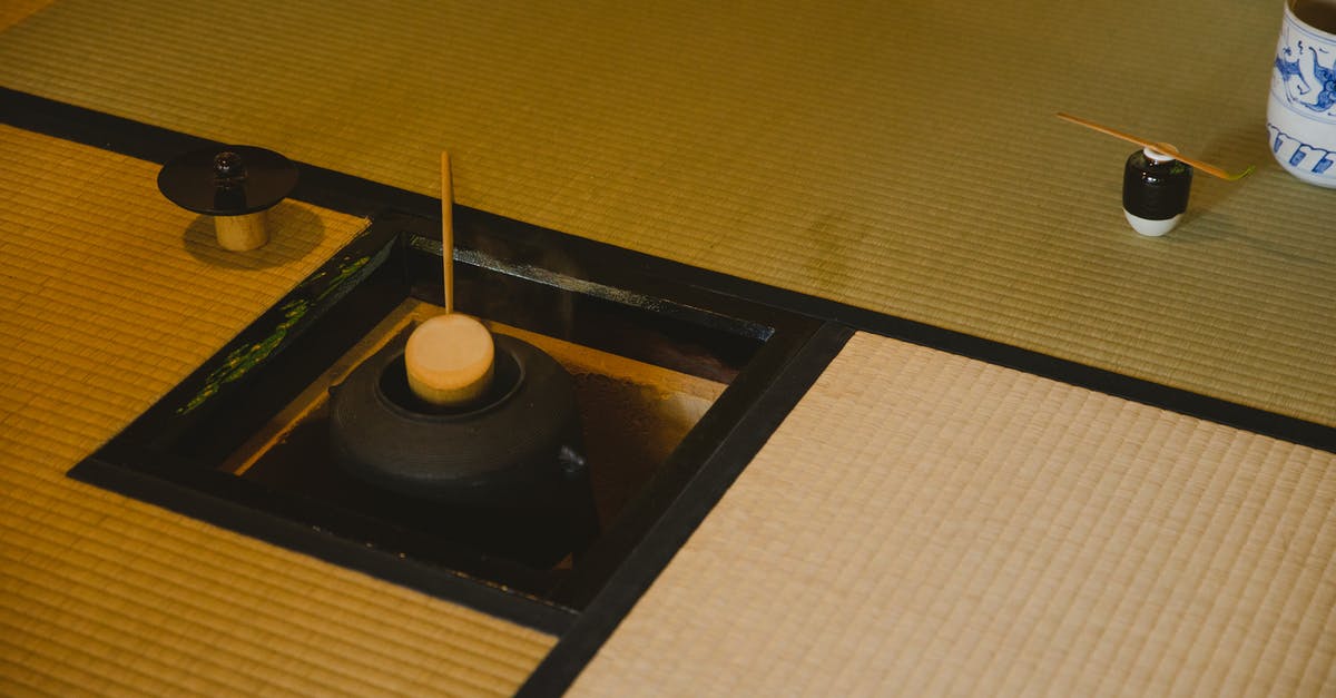 Inside Japan during the 180 days temporary visa reset - High angle of traditional Japanese tea ceremony in Urasenke style in spacious light room on floor with fire pit with kettle and water ladles near pot