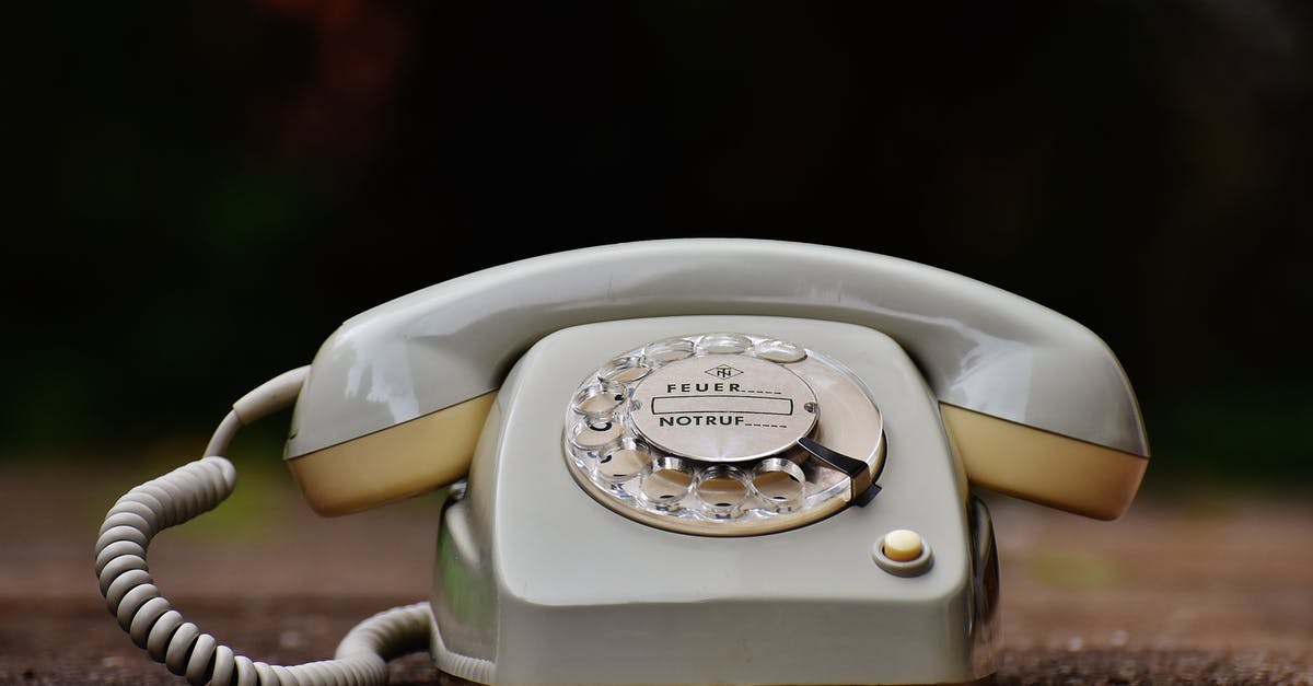 International Phone Numbers in Cell - Gray Rotary Telephone on Brown Surface