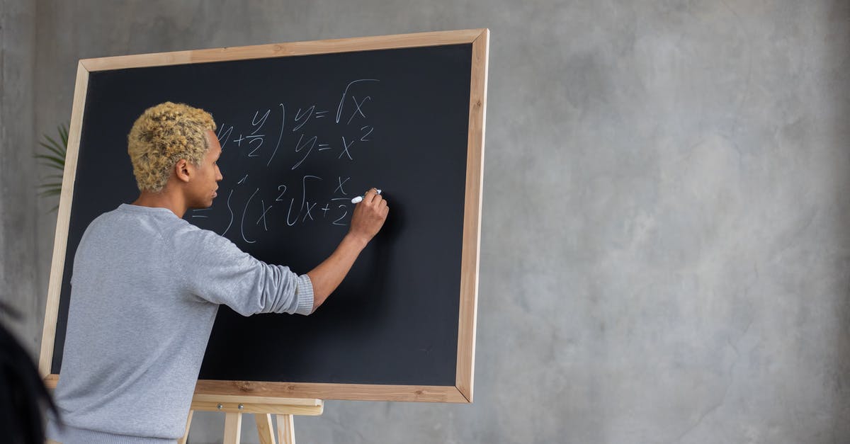 International Student With a UK Visa Question - Serious black student writing mathematical example on blackboard