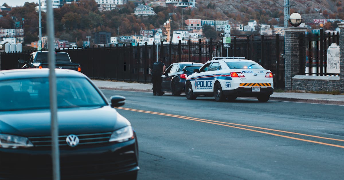 Inter-state driving law references - Anonymous policeman checking car on street