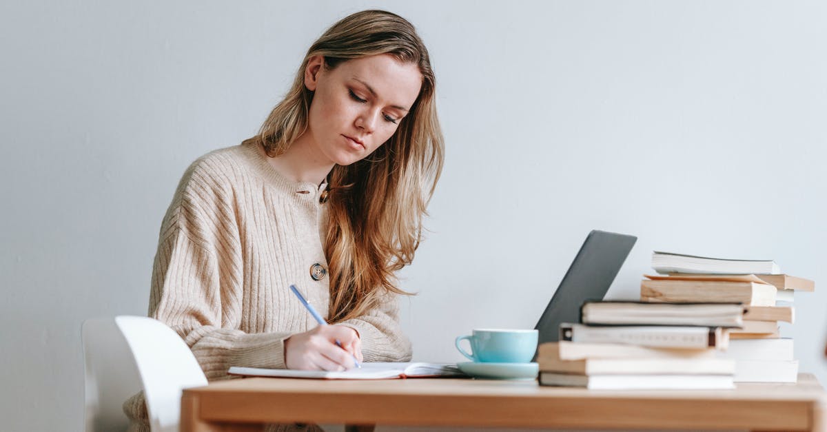 Is 12 minutes connection in Bristol Temple Meads long enough? - Concentrated female taking notes in planner near heap of many books and cup of strong coffee on white background