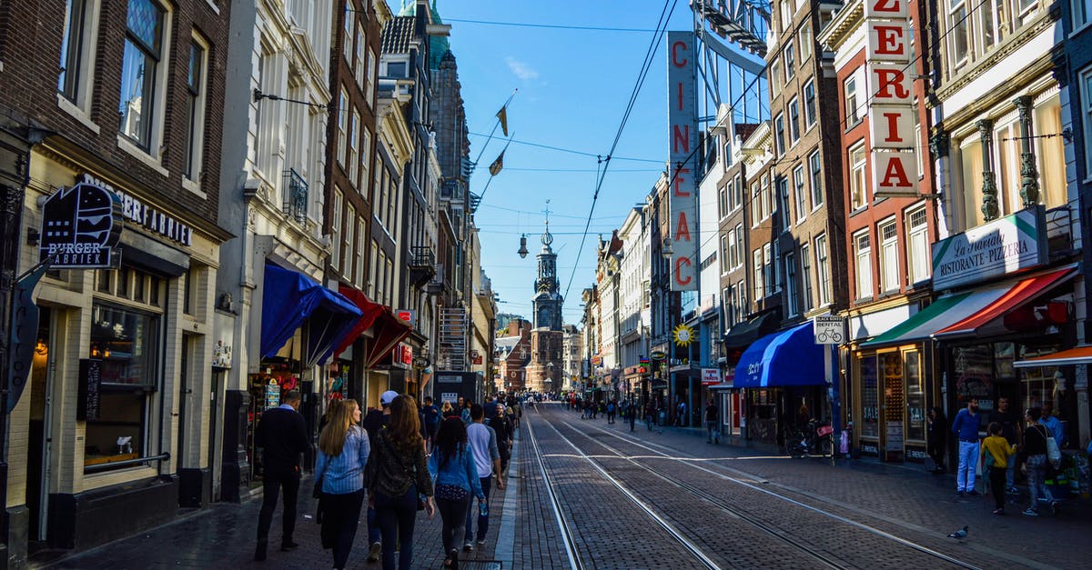 Is 1.5hr layover in Amsterdam Schiphol sufficient for intra-Schengen flights? - People Walking on Street Between Buildings