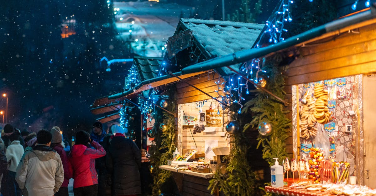 Is 31st of December a public holiday in Japan? - Crowd of many people entertaining near Christmas cafe decorated with shiny baubles and glowing garland