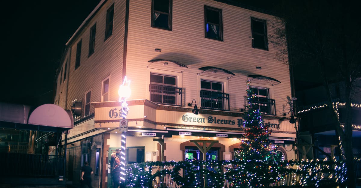 Is 31st of December a public holiday in Japan? - Exterior of modern pub surrounded with glowing green Christmas trees and decorations in late evening