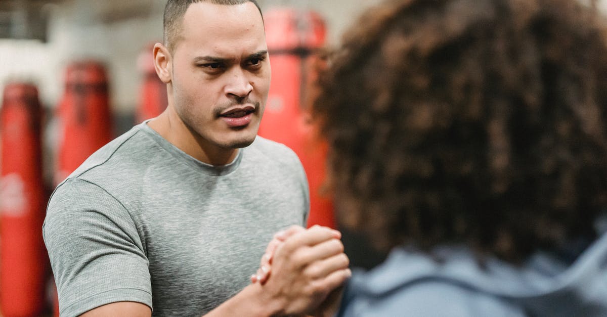 Is 'wai' greeting a serious thing? Is it inappropriate to 'over-wai'? - Muscular young ethnic male trainer shaking hand of unrecognizable African American female before workout in gym