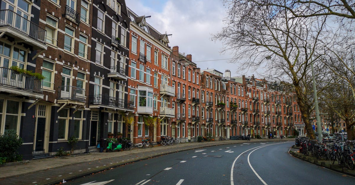 Is a 1 hour layover in Amsterdam sufficient? - Cars Parked on Side of the Road Near Buildings