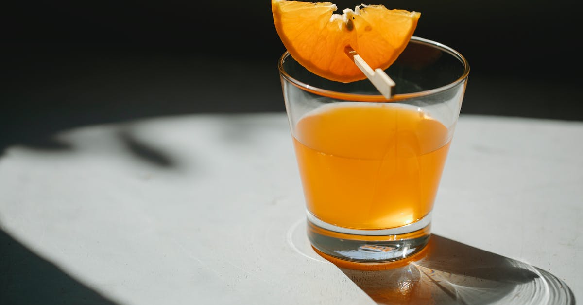 Is a stick deodorant a "liquid or gel" for EU airport security? - Glass of alcohol drink decorated with slice of orange on wooden stick placed on white table on blurred black background