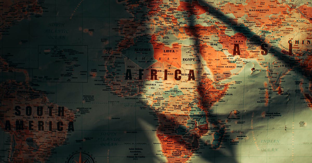 Is a transit visa required for South Africa? - Top view of paper world map with continents and different countries oceans and seas placed in sunny room