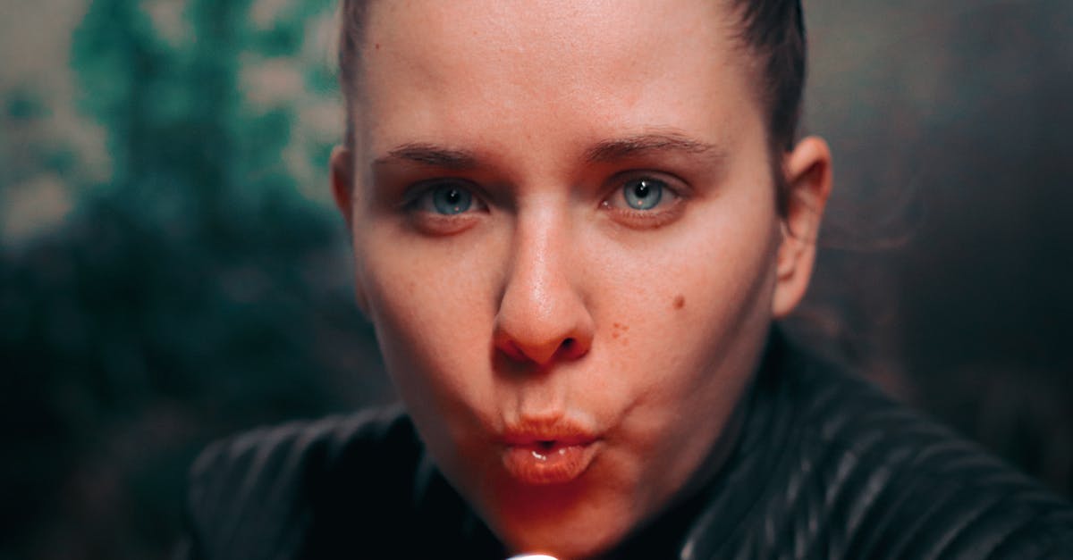 Is blowing your nose in public that badly seen in Japan? - Close-Up Photo of Woman Blowing a Lighter