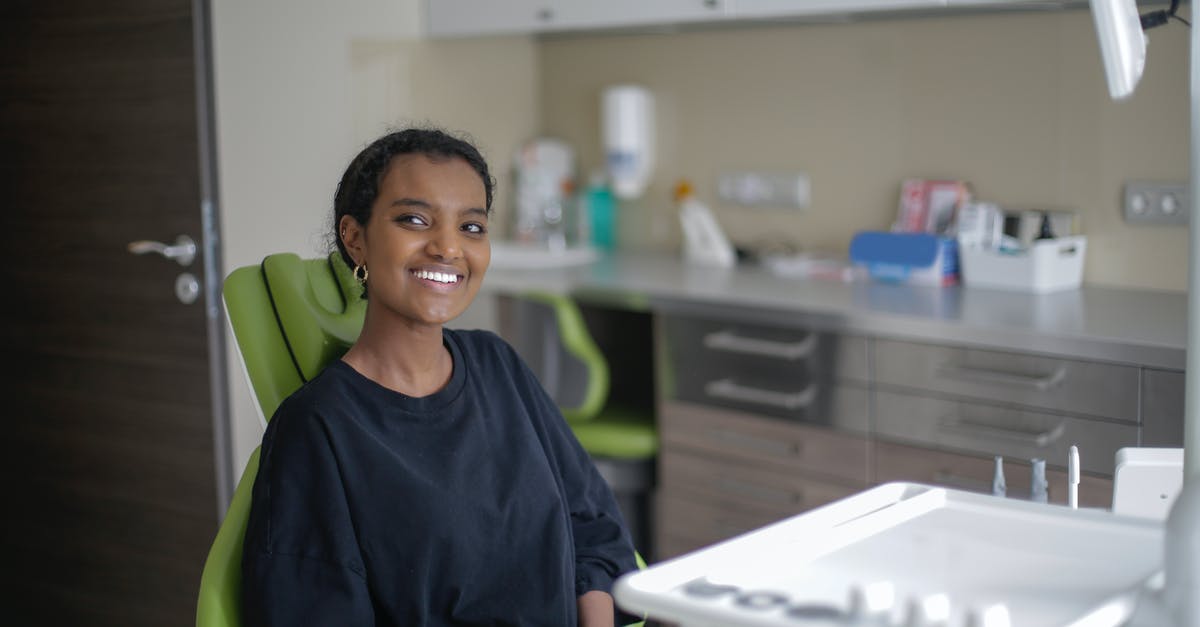 Is Canadian TRV open to visit visas at this point? - Cheerful African American woman sitting on dental chair in clinic