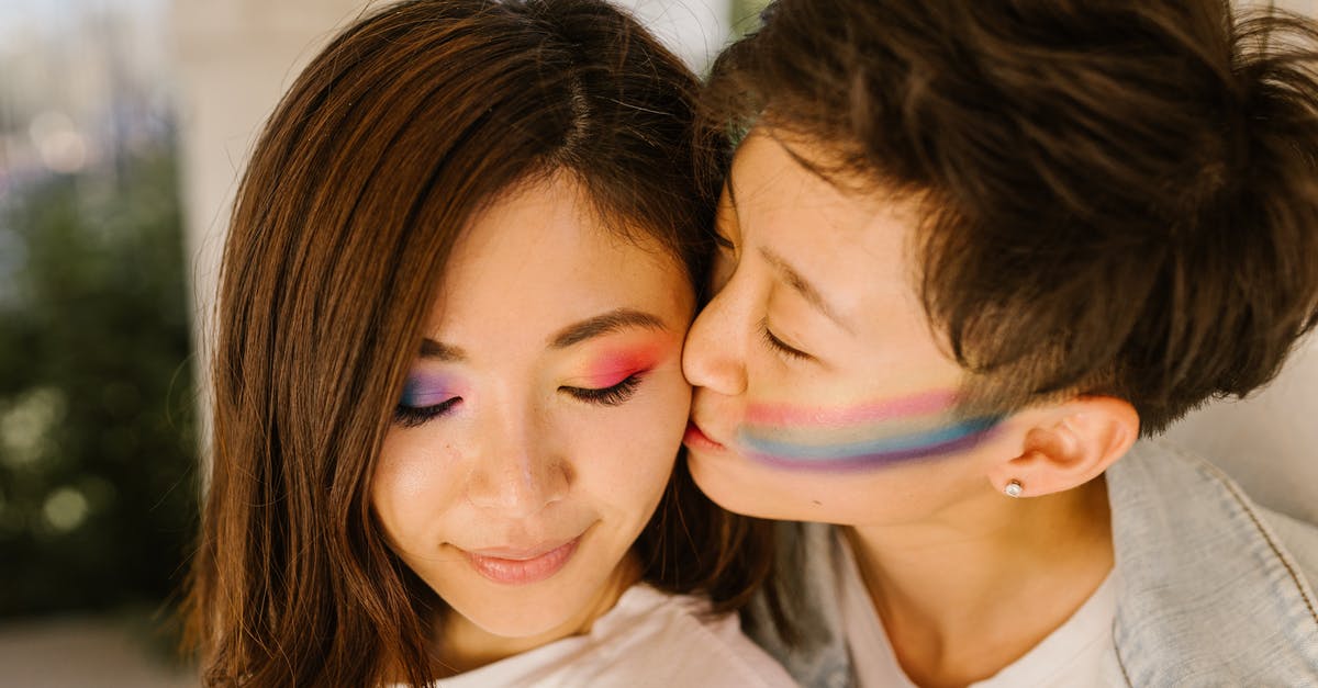 Is cheek kissing common in the US? - Lesbian Girl with Rainbow Painting on Cheek Fondly Kissing Partner 