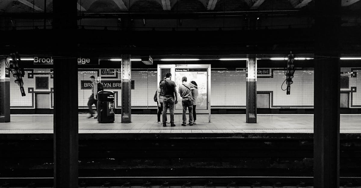 Is Colmar's railway station next to the city center? - Black and white of anonymous people waiting for train on platform of subway station